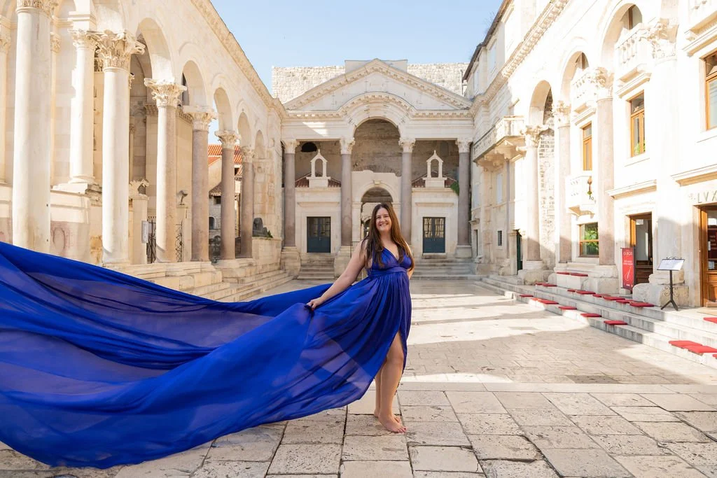 Dr. Hillary Hushower in a flowing blue dress in a sunlit courtyard